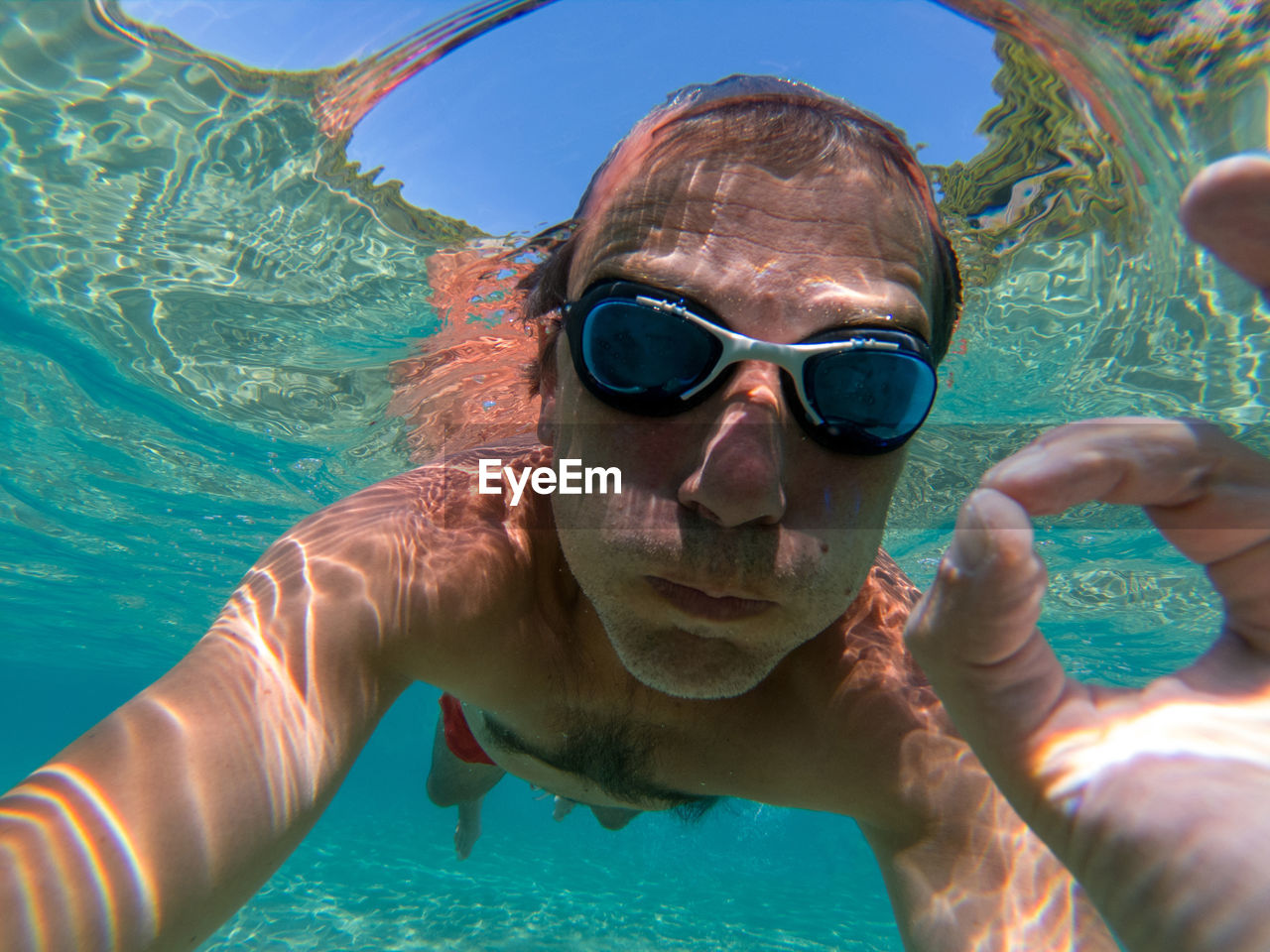 Portrait of shirtless man swimming in sea