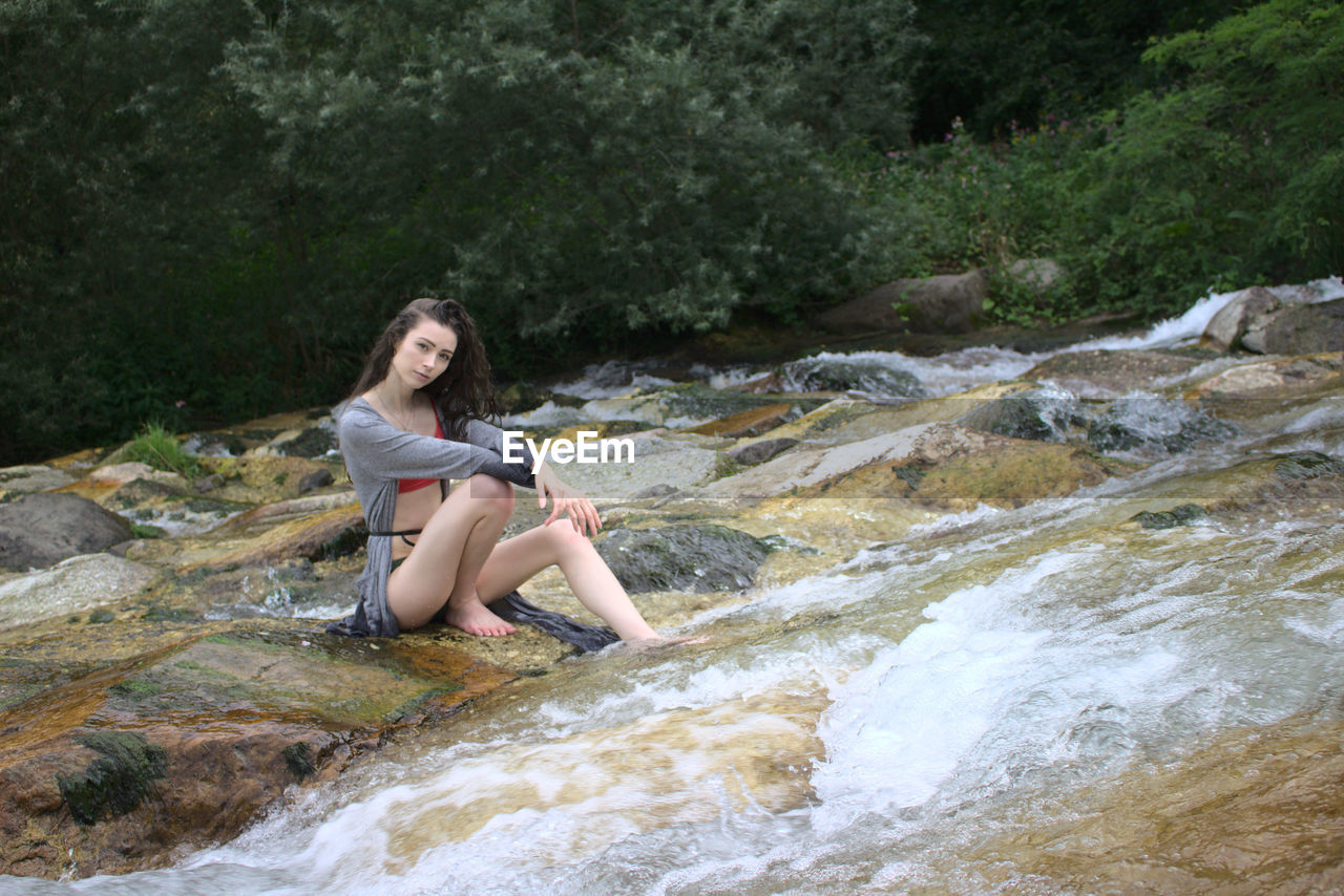 Full length of young woman in a waterfall 
