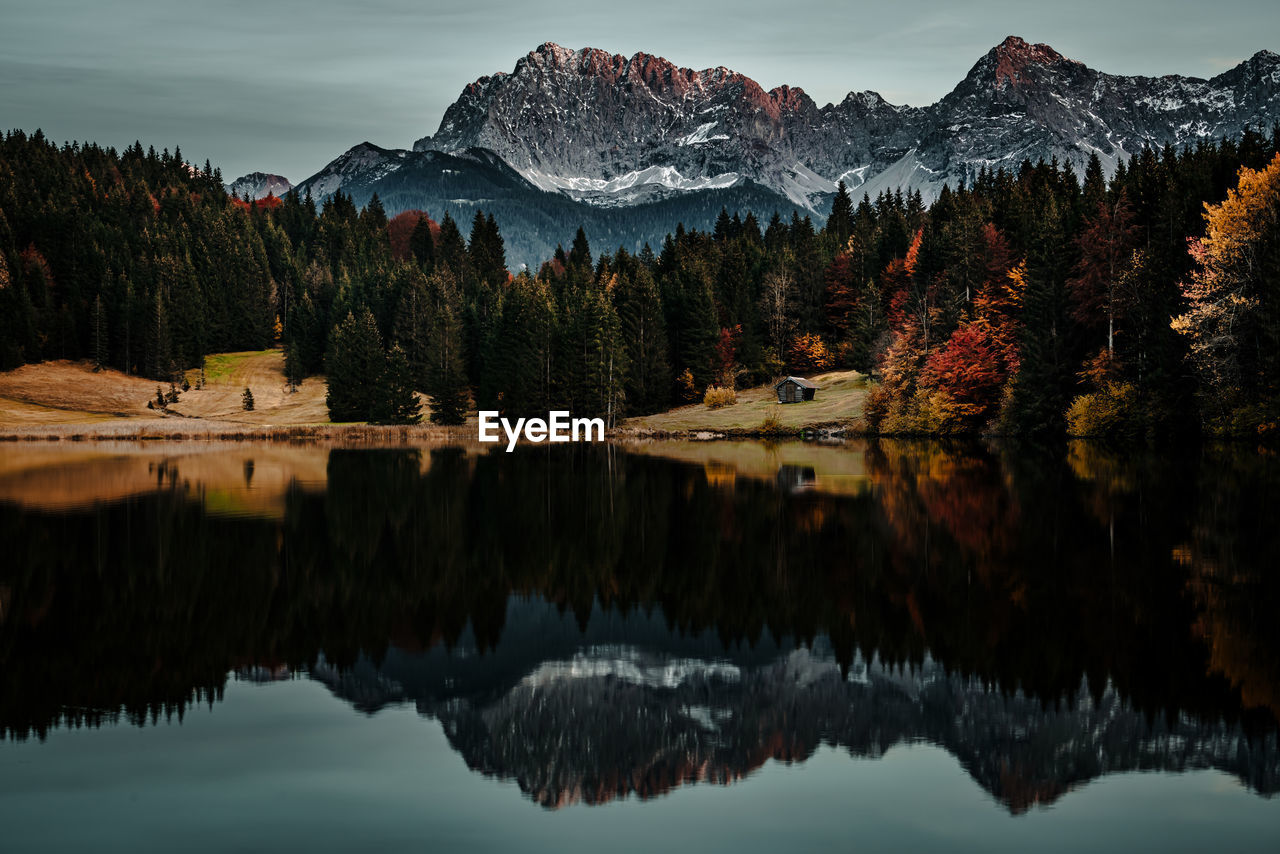 scenic view of lake by mountains against sky