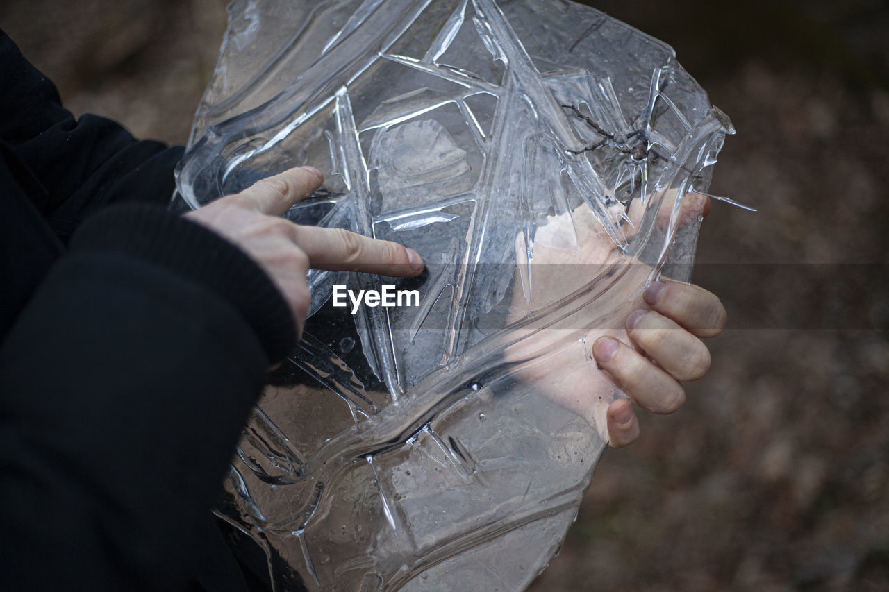 Close-up of hand holding ice outdoors