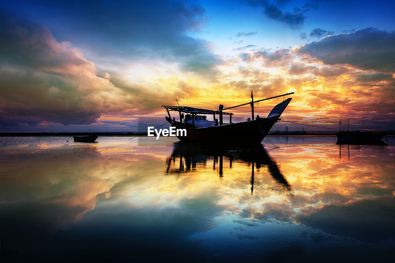 FISHING BOAT IN SEA AGAINST SKY AT SUNSET