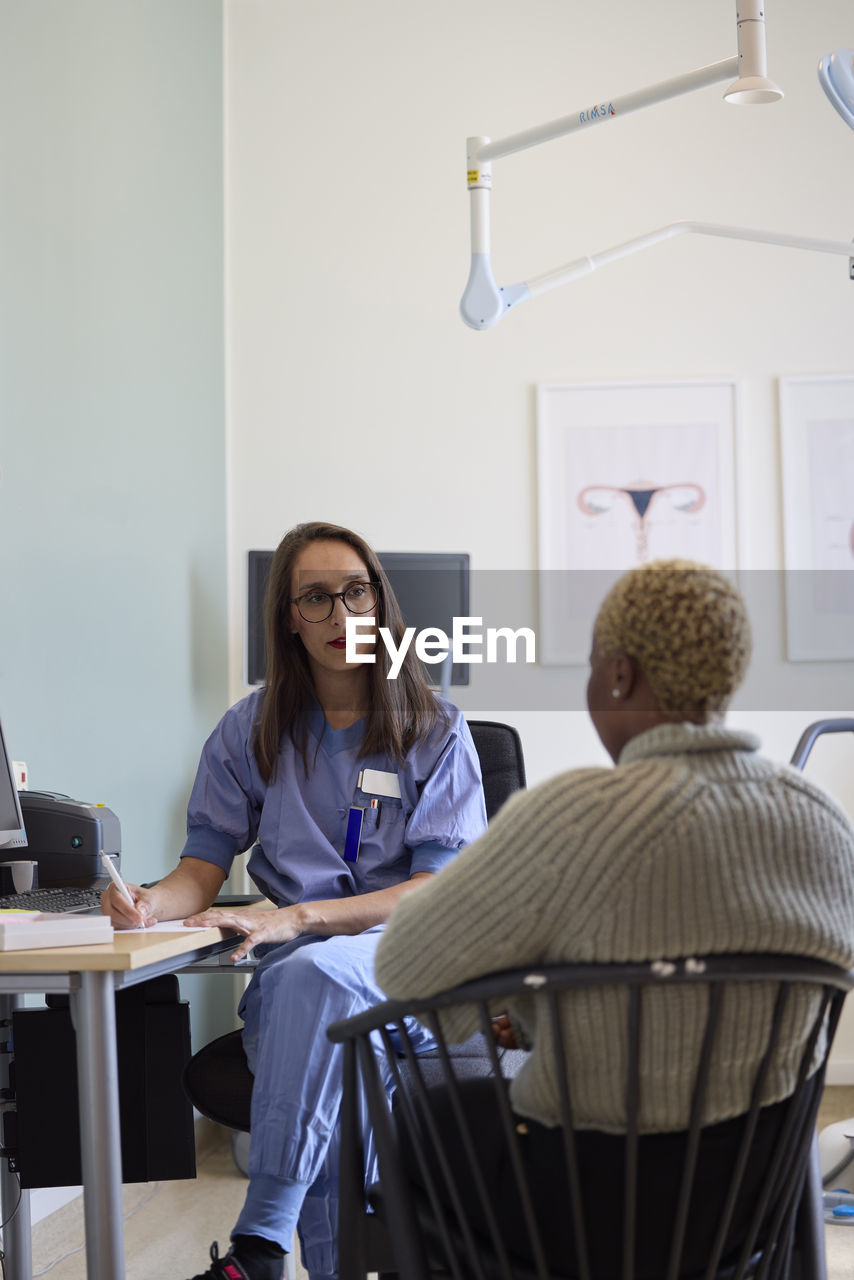 Doctor talking to female patient in office