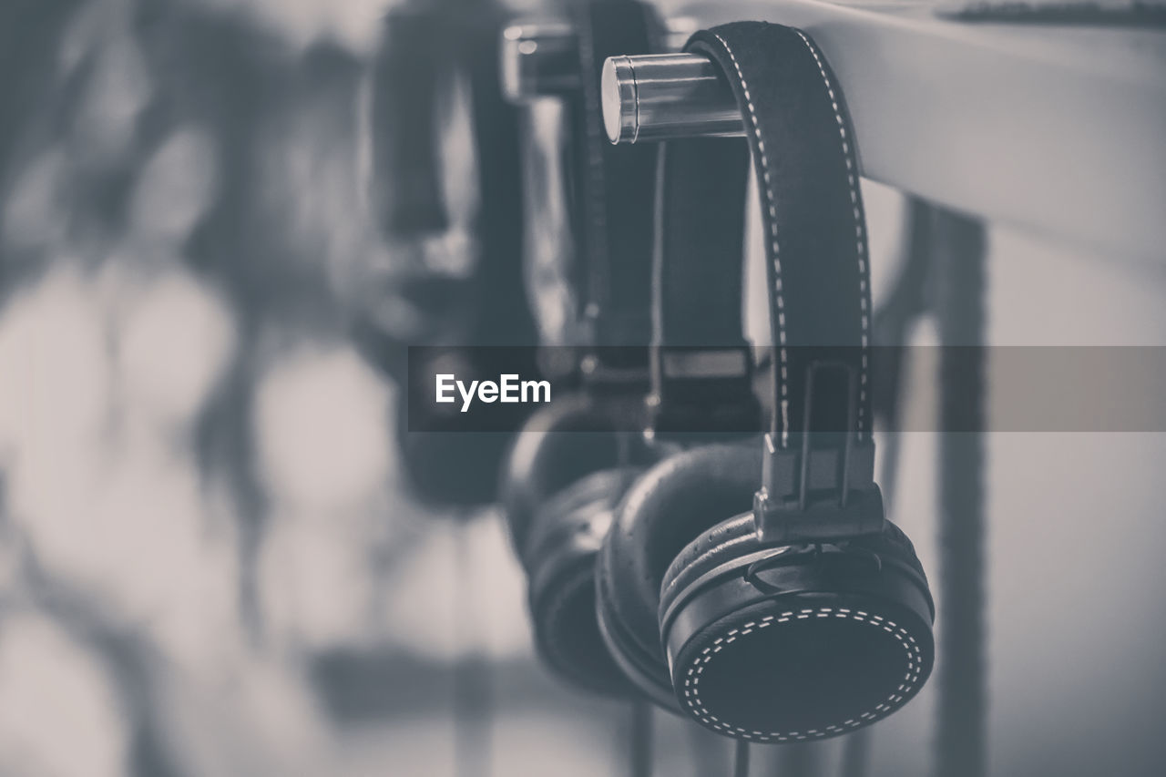 Close-up of headphones hanging on metal