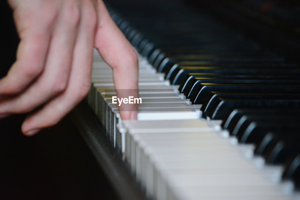 Cropped image of person playing piano