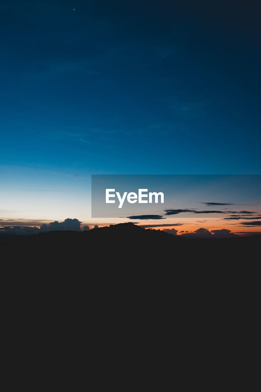 SCENIC VIEW OF SILHOUETTE LANDSCAPE AGAINST SKY AT SUNSET