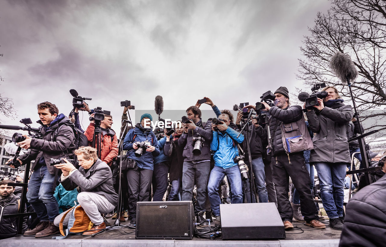 GROUP OF PEOPLE STANDING AGAINST THE SKY