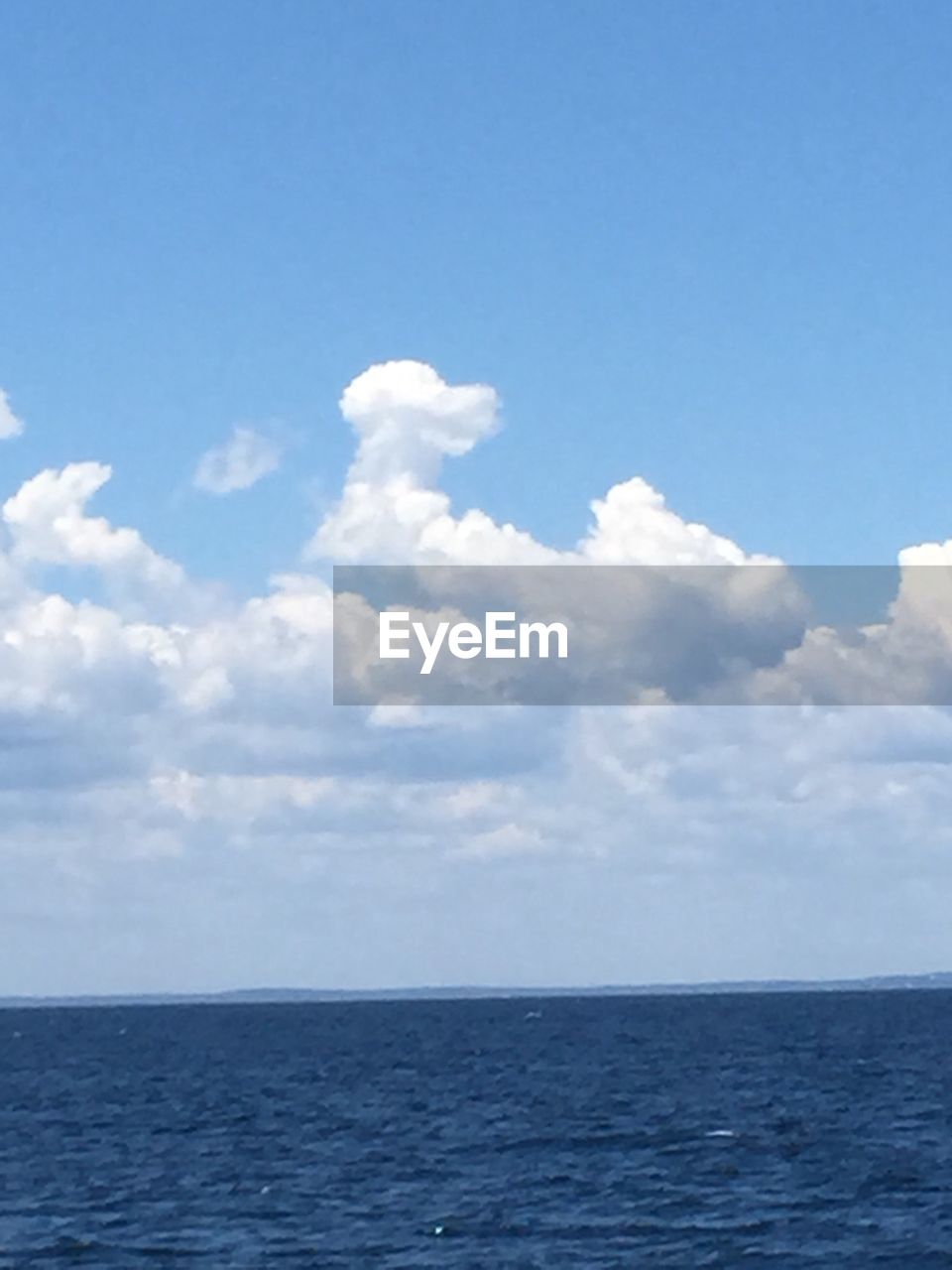 Scenic view of calm sea against cloudy sky