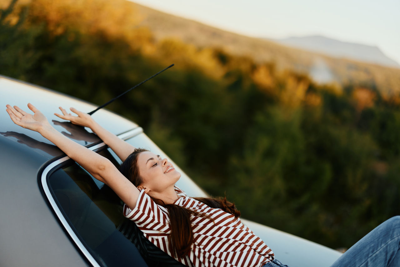 low section of woman sitting on car