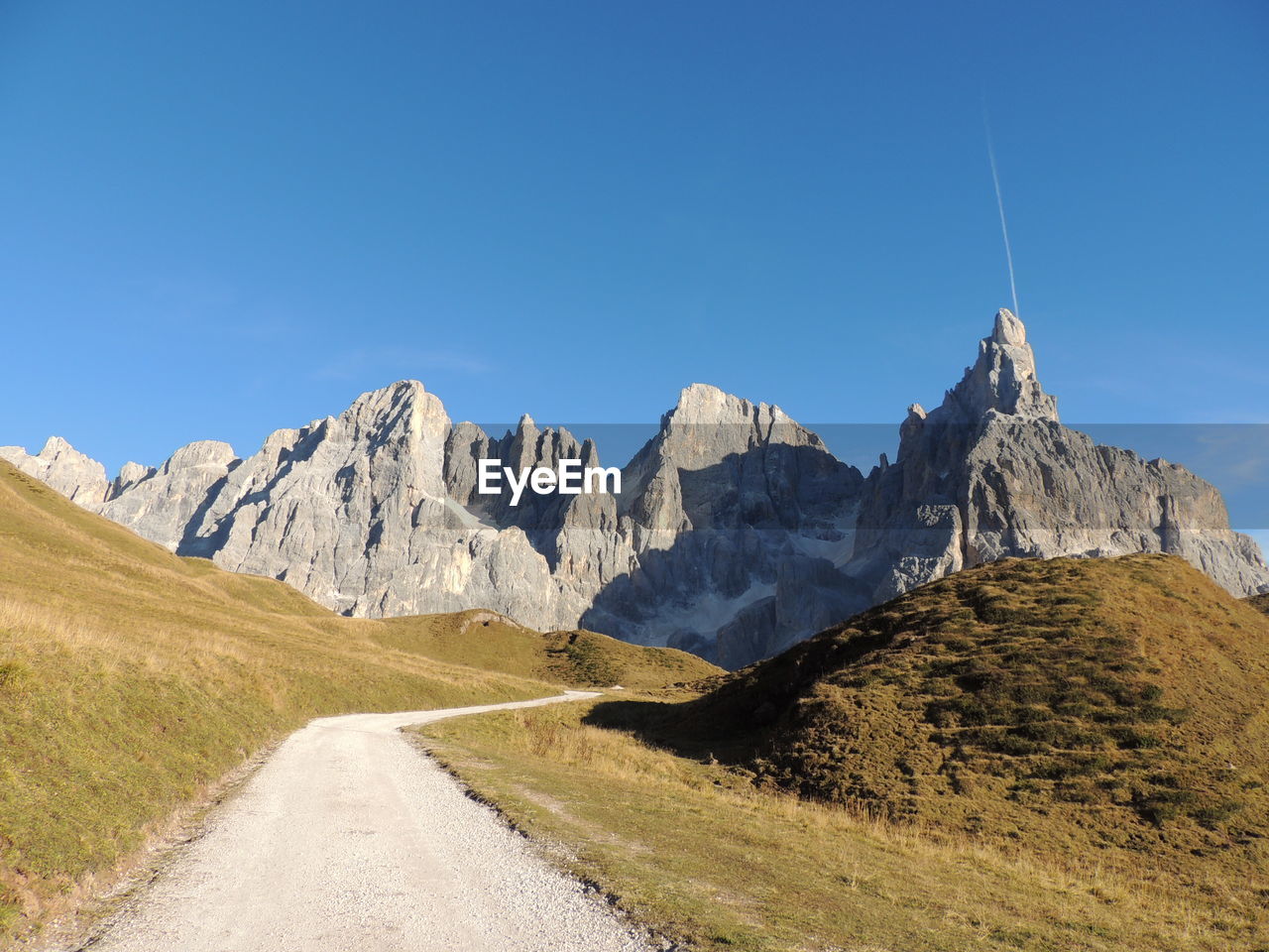 Low angle view of footpath leading to rocky mountains