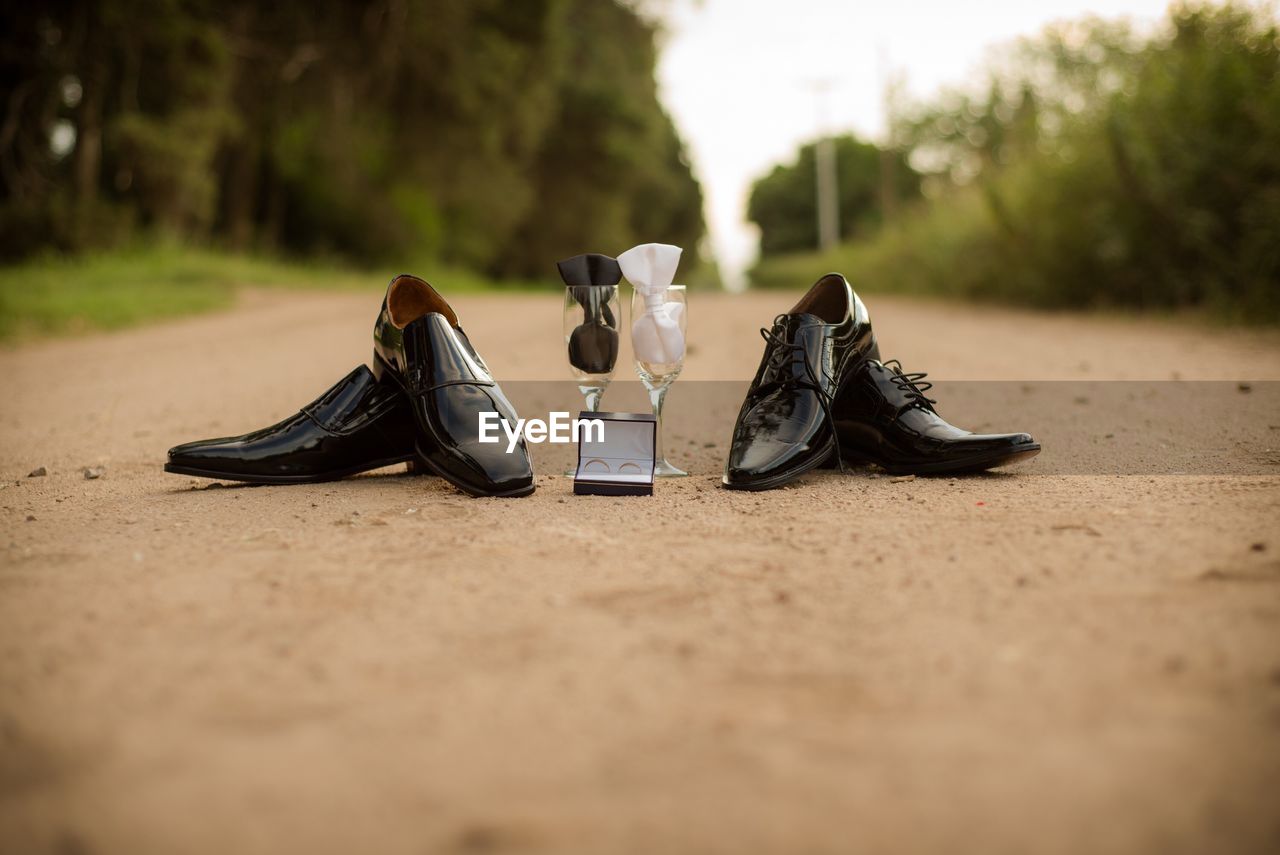 Wedding rings with shoes and wineglasses on land