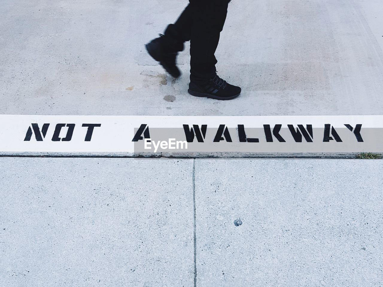 Low section of man walking on road