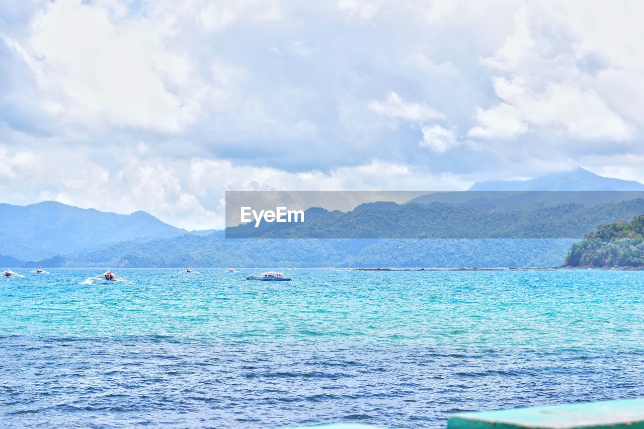 SCENIC VIEW OF SEA BY MOUNTAIN AGAINST SKY