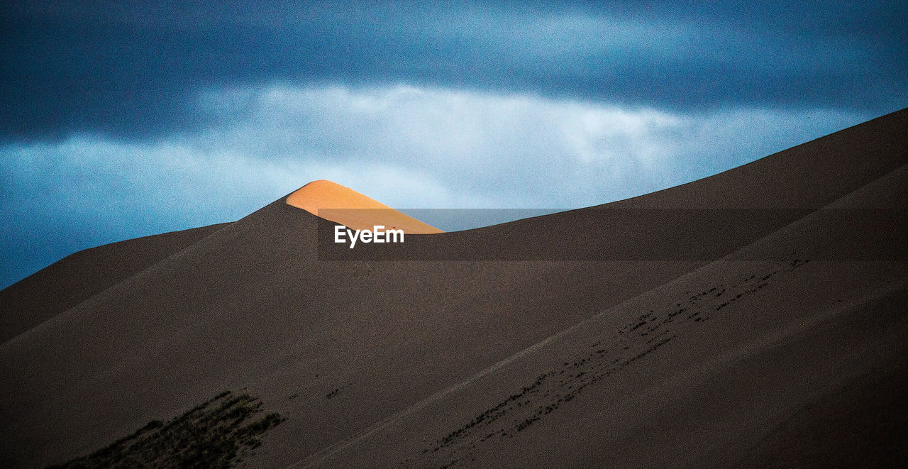 Low angle view of sand dunes in desert against sky