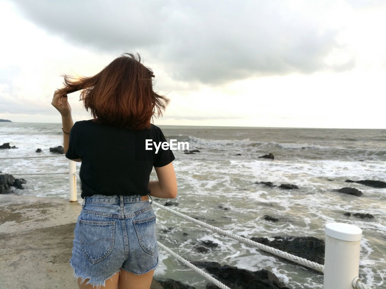 Rear view of woman standing on beach