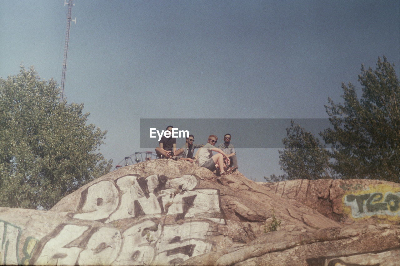 WOMAN STANDING ON TREE TRUNK