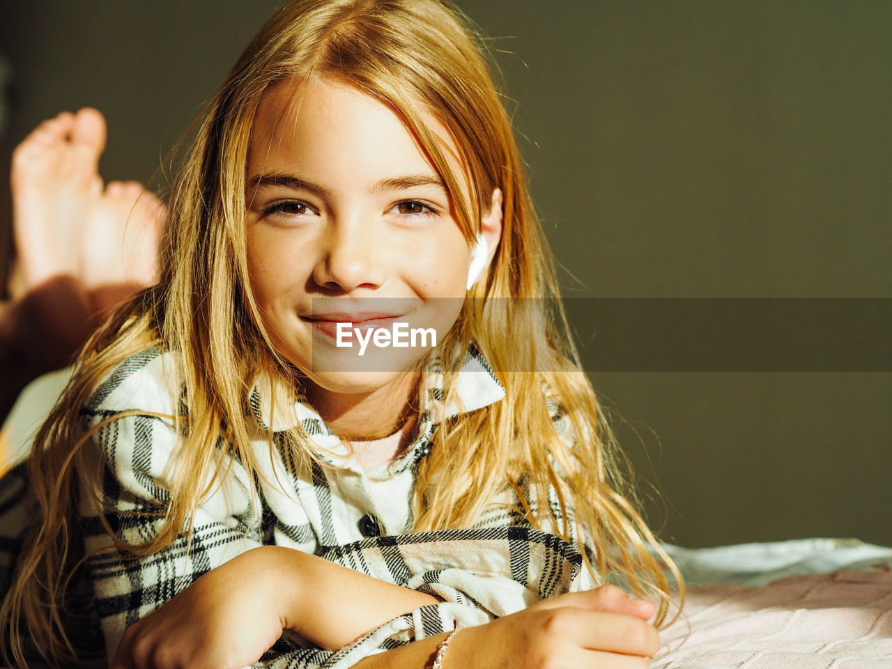 Portrait of cute girl lying on bed at home