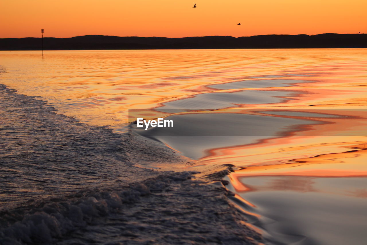 SCENIC VIEW OF BEACH DURING SUNSET