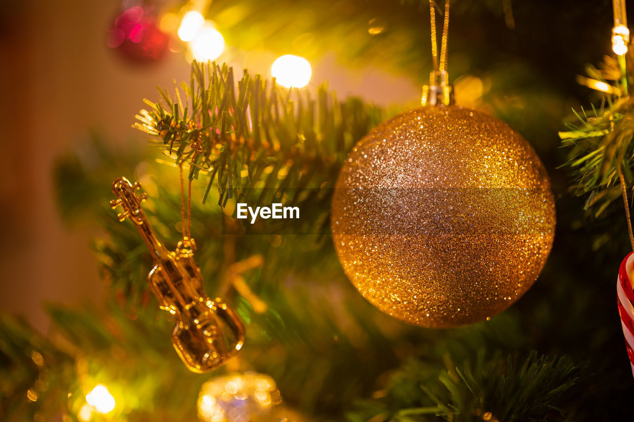 CLOSE-UP OF CHRISTMAS DECORATION HANGING ON TREE AT NIGHT