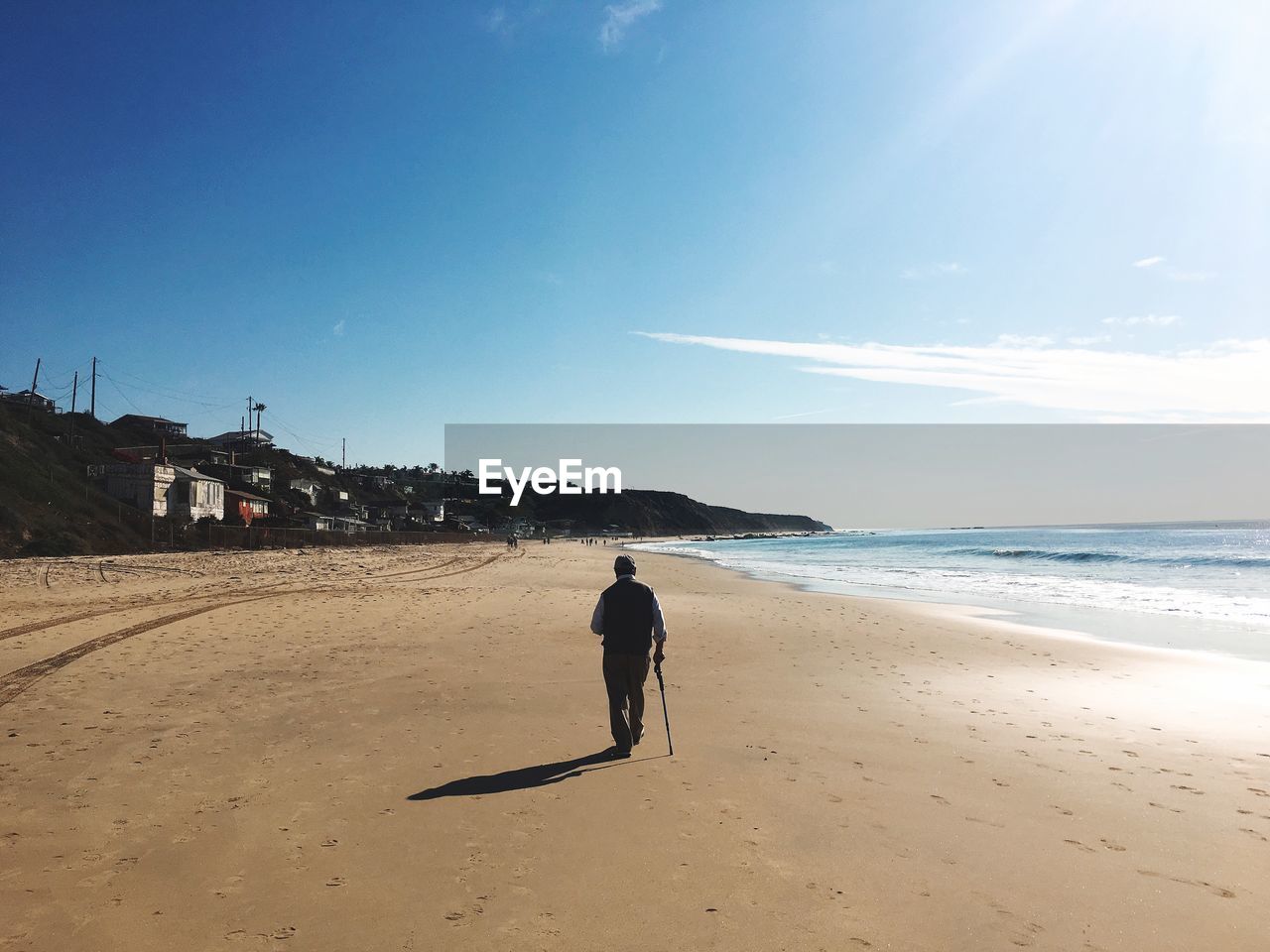 Man walking at beach against sky