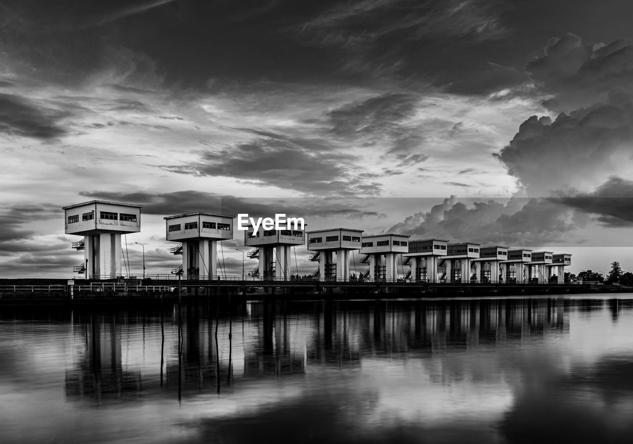 BRIDGE OVER RIVER BY BUILDINGS AGAINST SKY