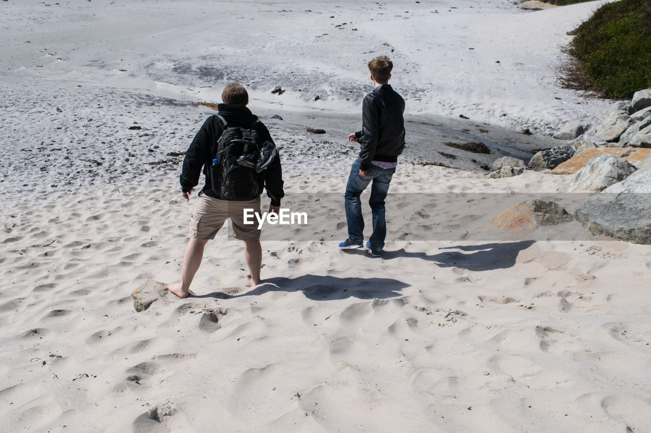 Tourists standing on sand