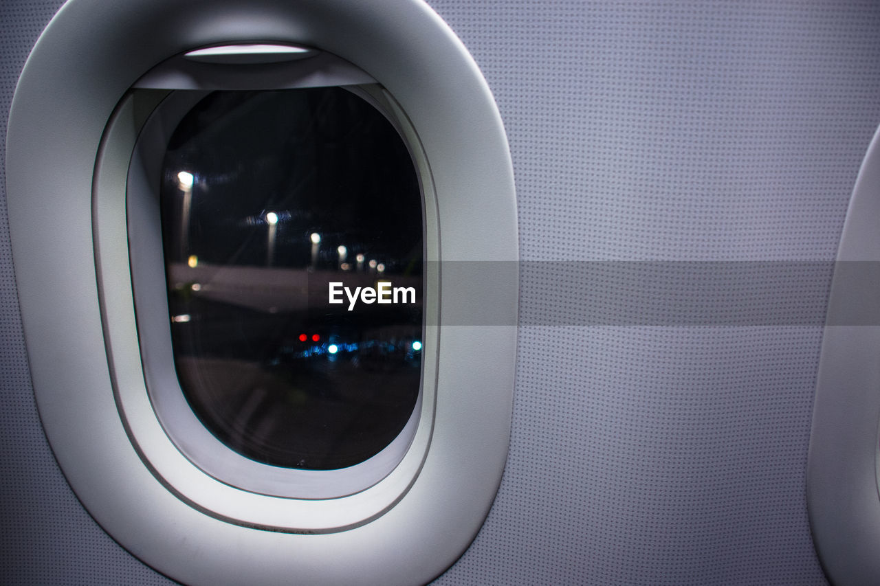 REFLECTION OF ILLUMINATED WINDOW IN AIRPLANE