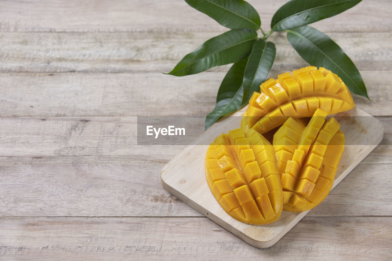 food, food and drink, wood, plant, freshness, leaf, fruit, plant part, produce, pineapple, healthy eating, indoors, no people, wellbeing, yellow, table, studio shot, vegetable, dish, still life, high angle view, nature