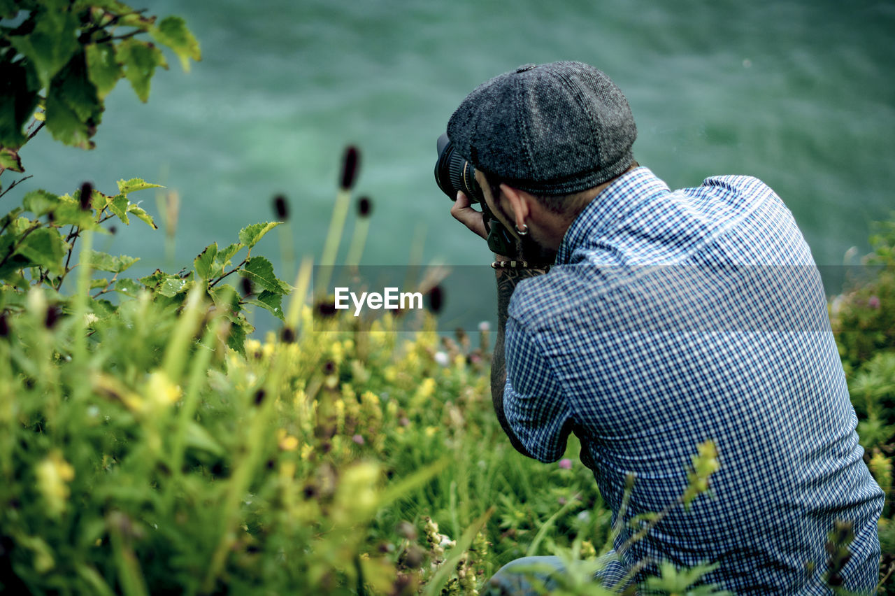 Rear view of man sitting amidst plants