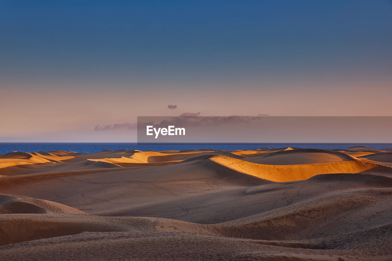 Scenic view of beach against sky during sunset