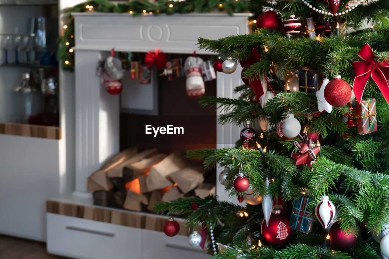 Christmas tree is in the living room is decorated in red and white.