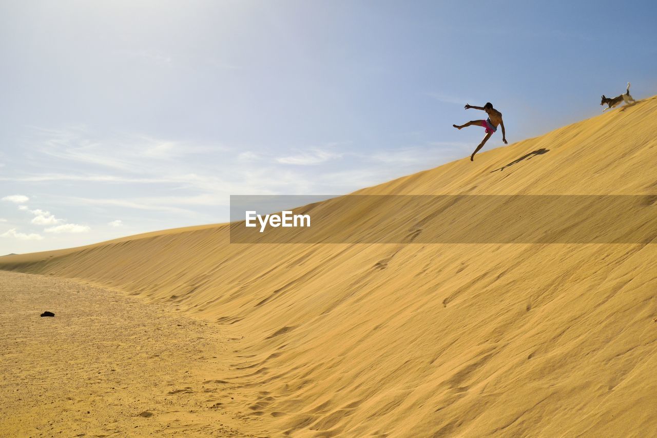 Man jumping a dune at corralejo