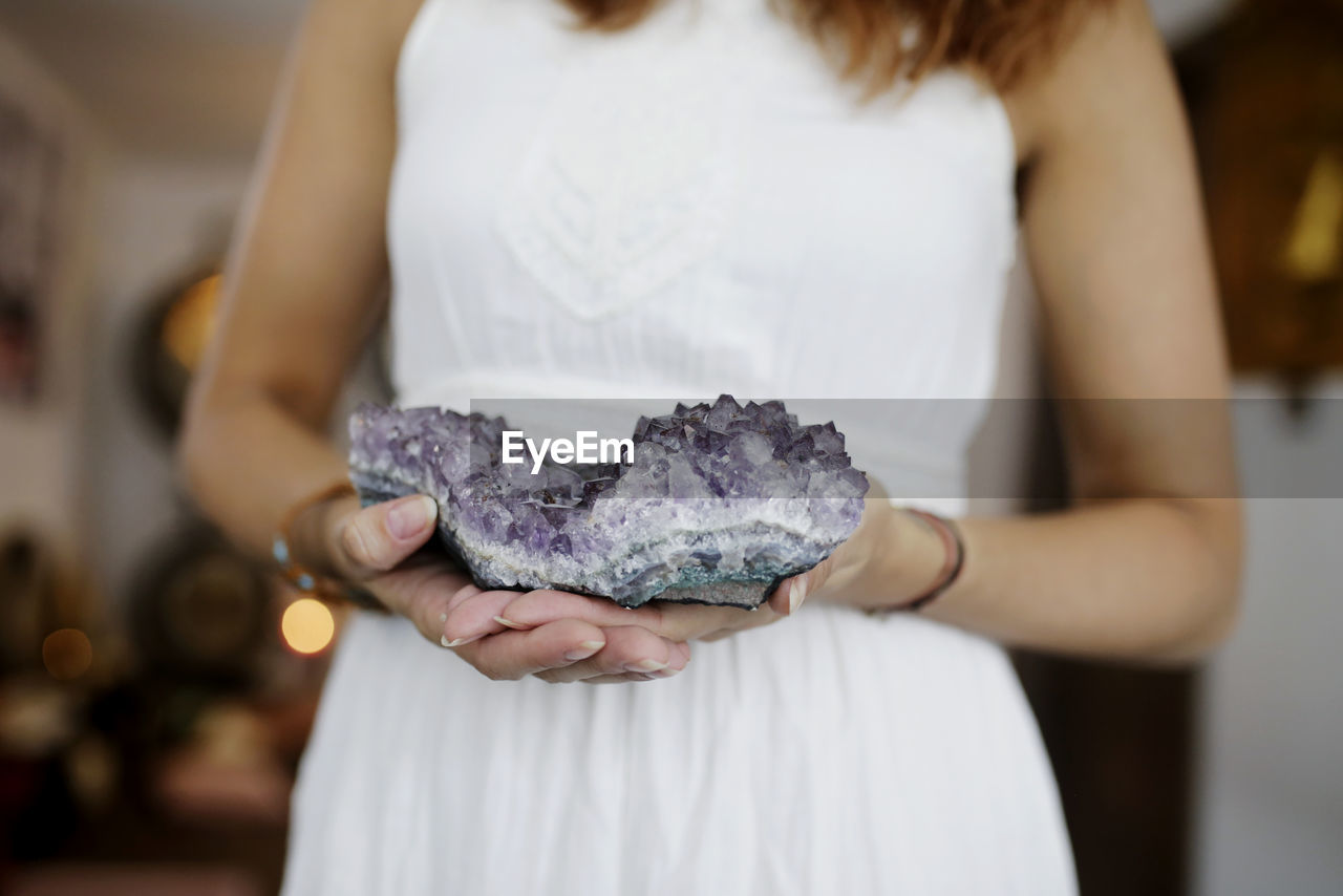 Midsection of woman holding crystal