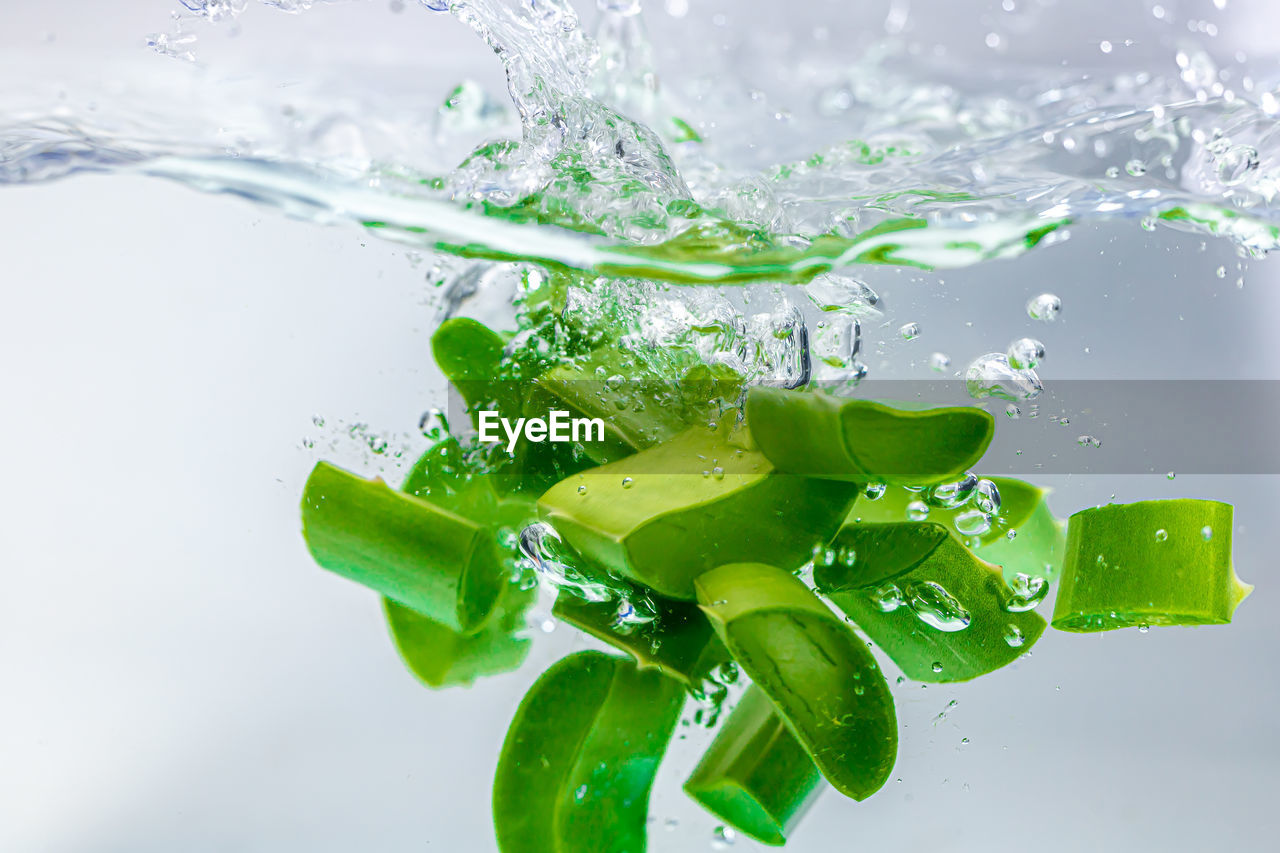 Close-up of water drops on glass over white background