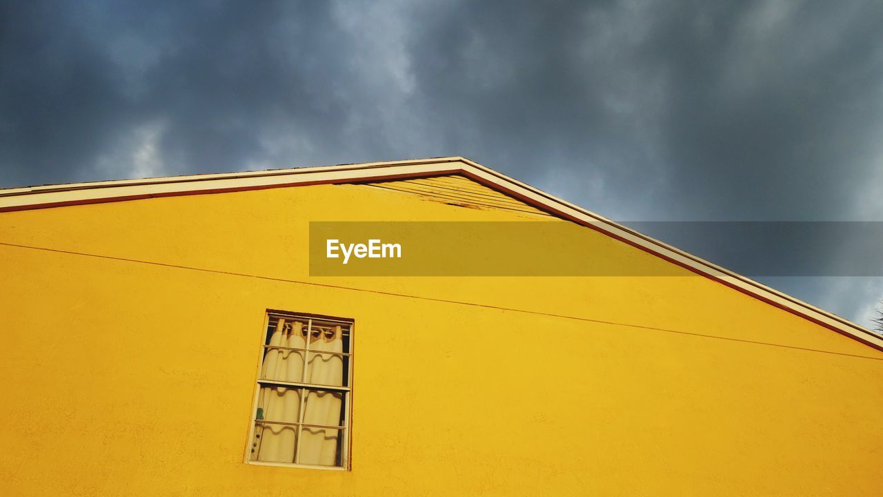 LOW ANGLE VIEW OF YELLOW STRUCTURE AGAINST SKY