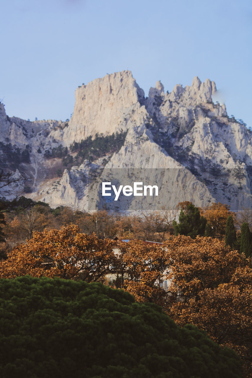 mountain, scenics - nature, nature, sky, environment, beauty in nature, landscape, wilderness, mountain range, plant, rock, land, no people, travel destinations, snow, tree, travel, valley, tranquil scene, tranquility, non-urban scene, clear sky, outdoors, day, winter, cold temperature, plateau, autumn, tourism, blue, mountain peak, ridge, snowcapped mountain, idyllic, rock formation, pine tree, sunny