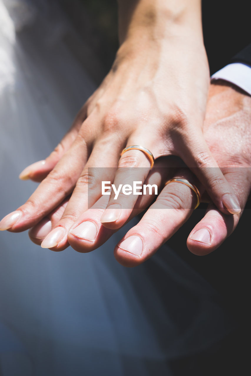 Cropped hands of couple wearing wedding rings