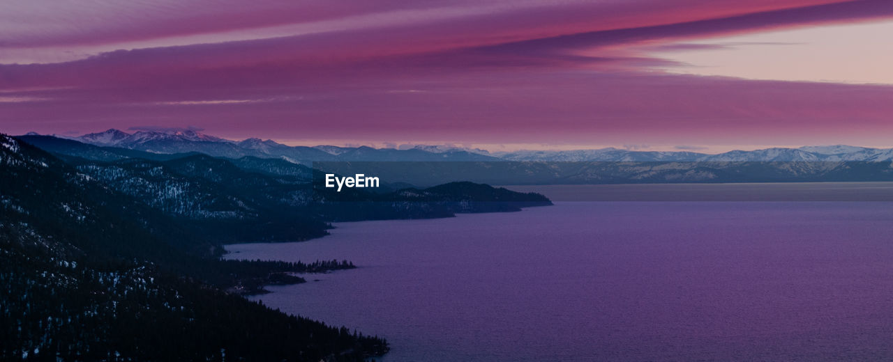 Scenic view of lake against mountains during sunset