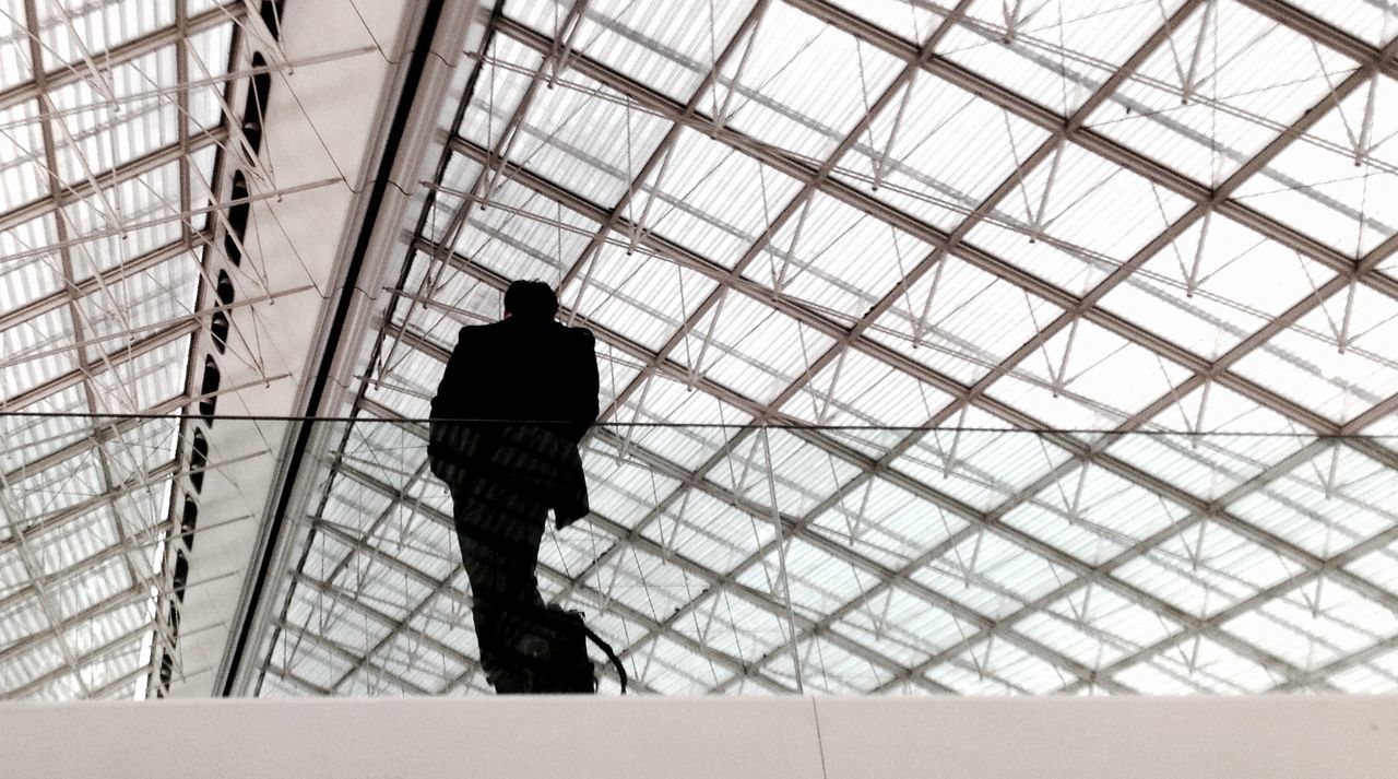 Low angle view of silhouette man standing on ceiling