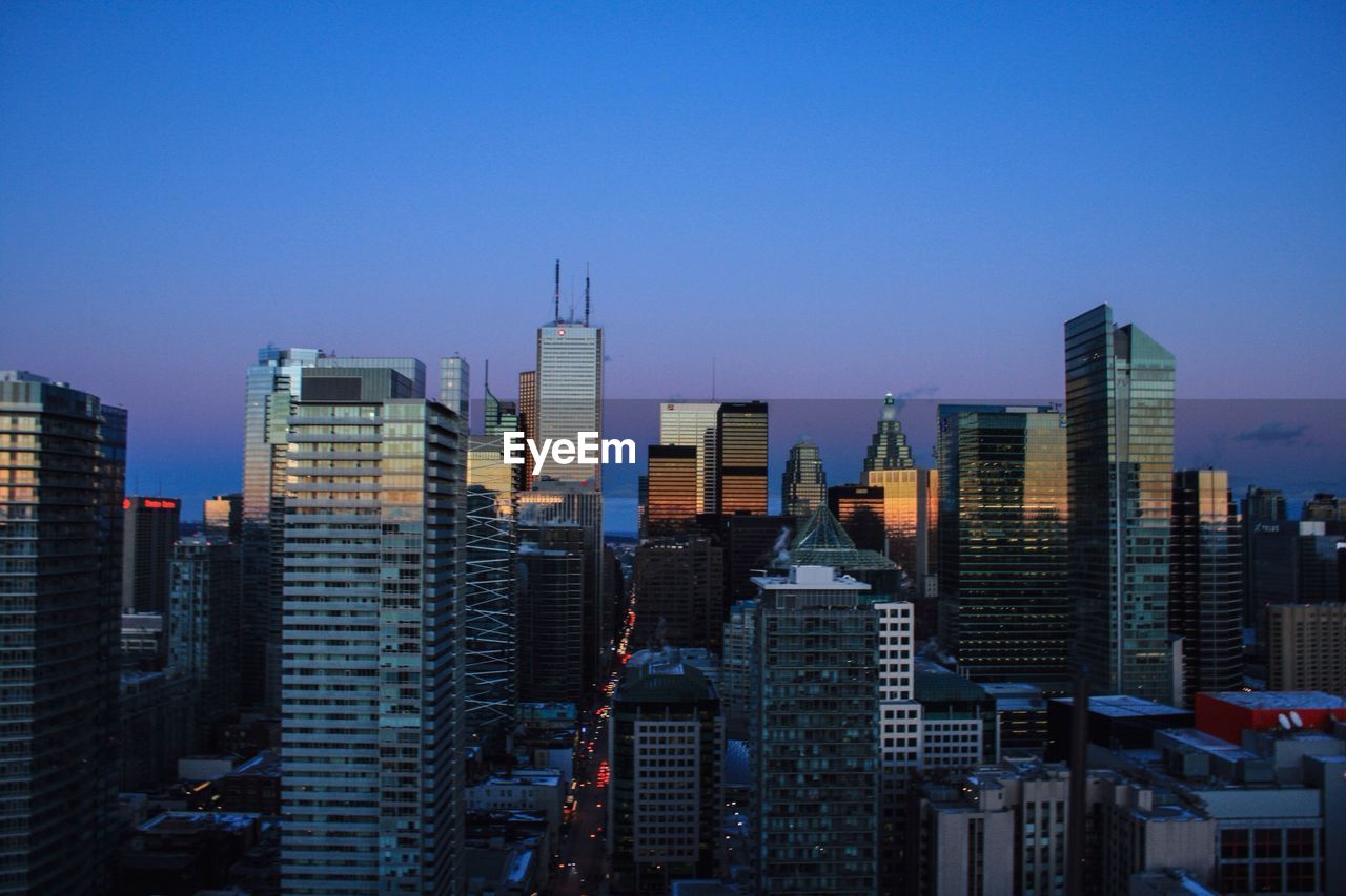 High angle shot of cityscape against blue sky