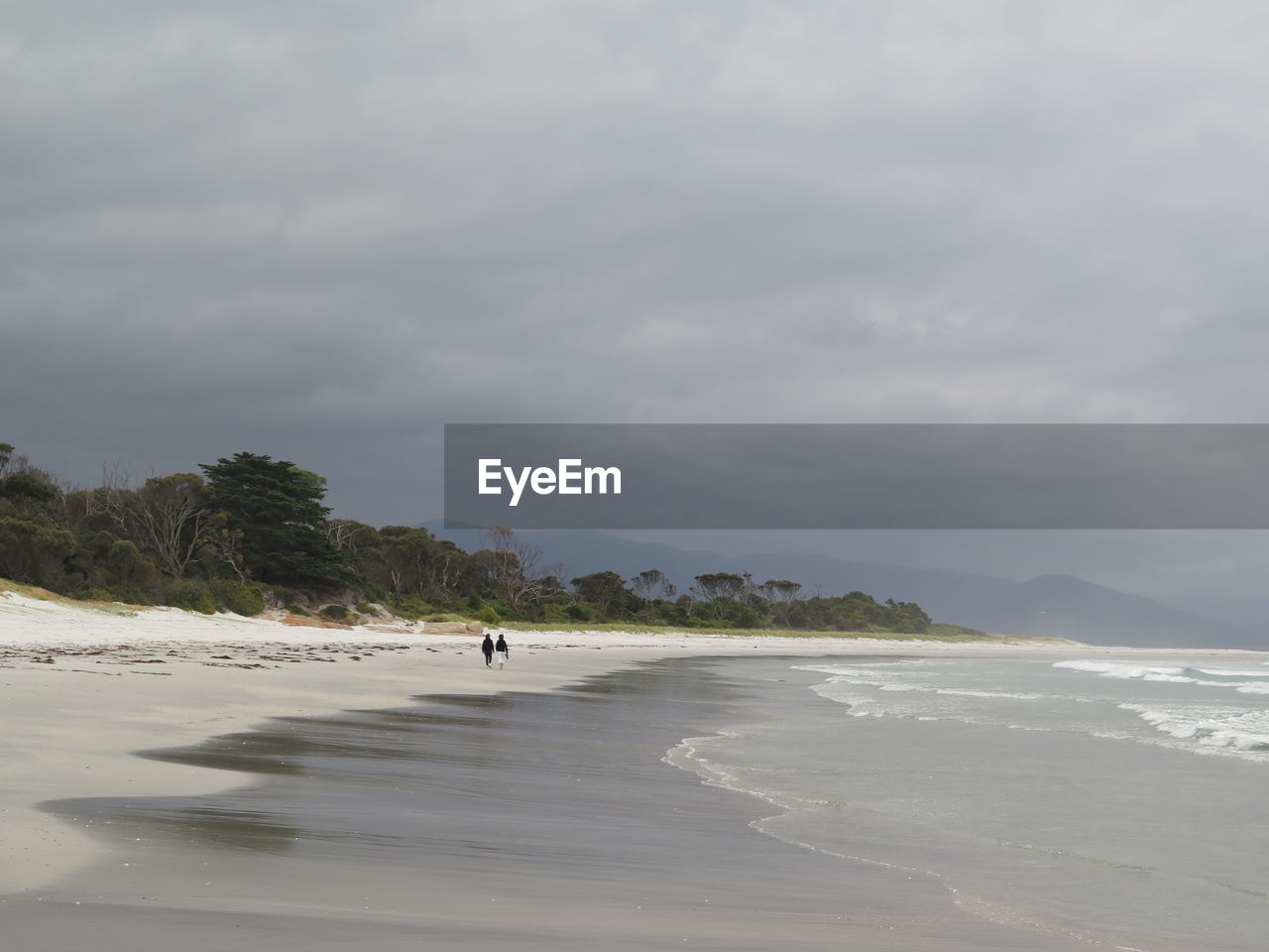 Scenic view of beach against cloudy sky