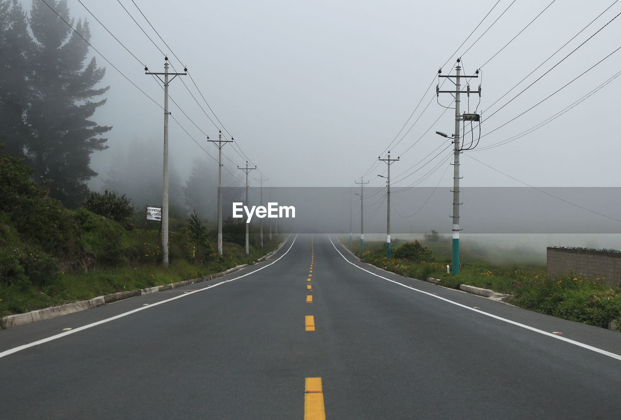 Empty road against cloudy sky