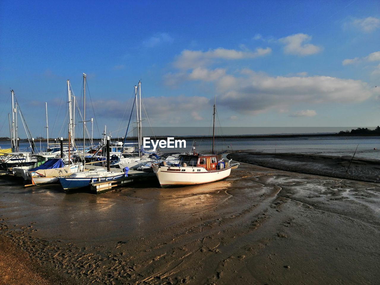 Sailboats moored on sea against sky