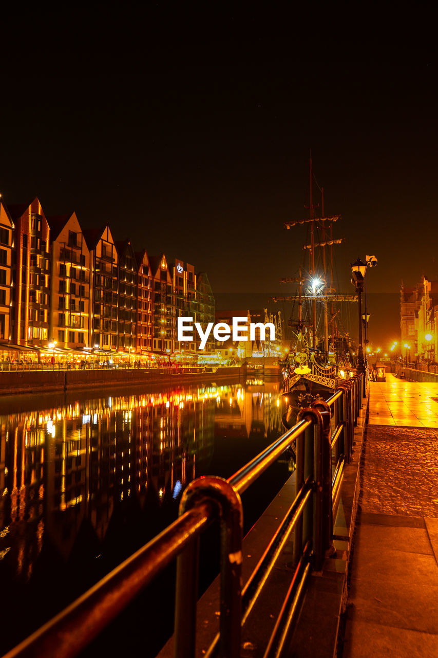 Old town in gdansk at night. the riverside on granary island reflection in moltawa river cityscape