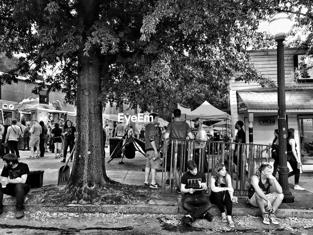 PEOPLE SITTING ON TREE TRUNK