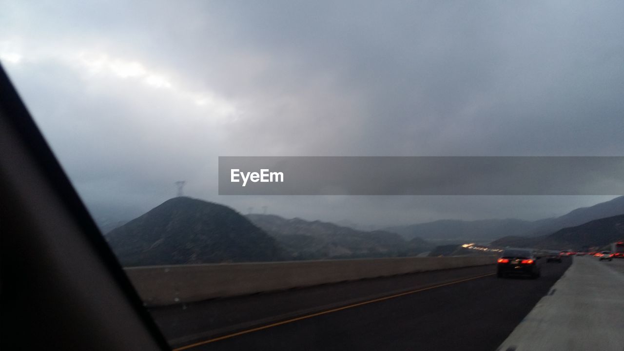 SCENIC VIEW OF MOUNTAINS AGAINST CLOUDY SKY