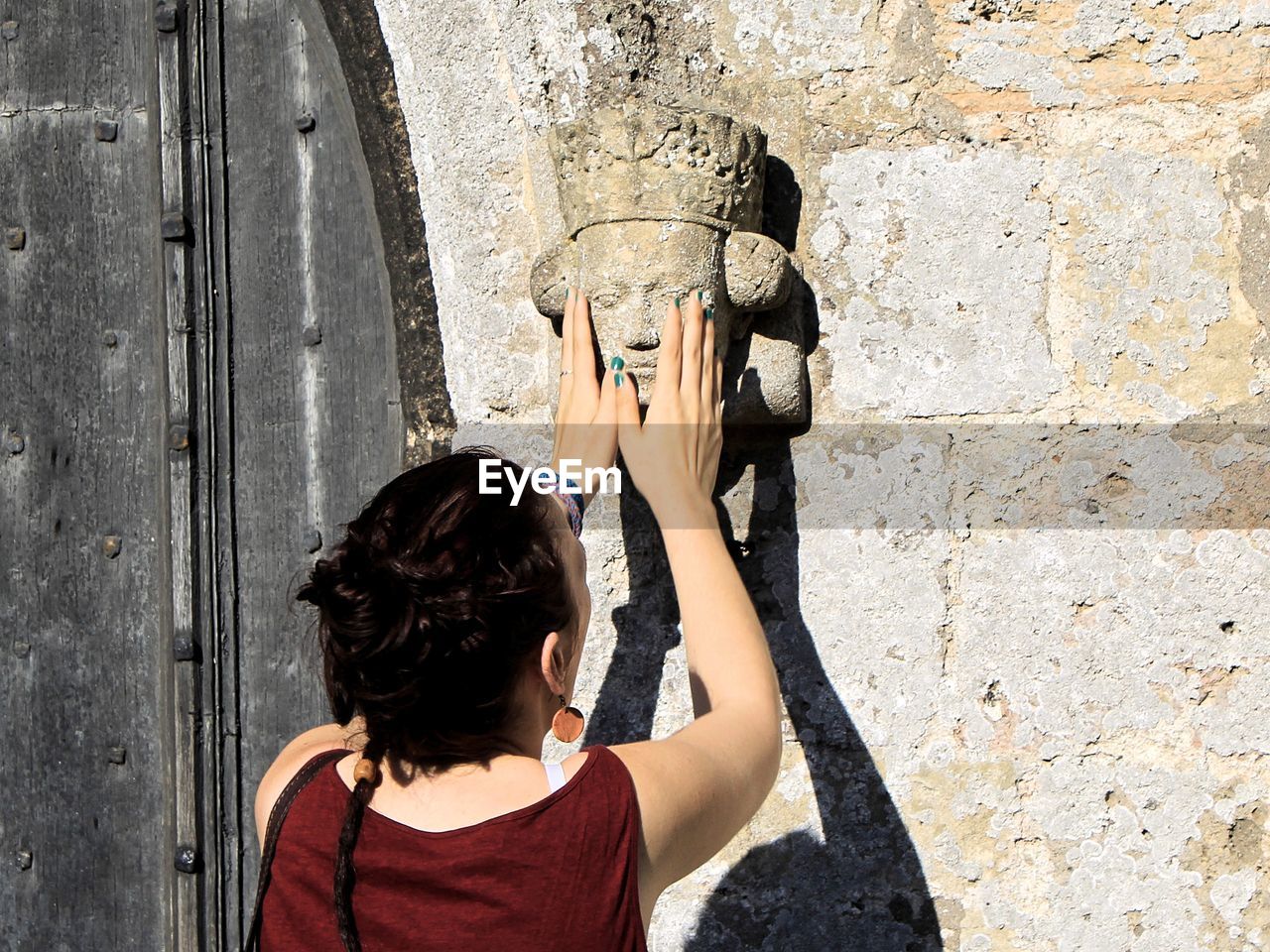 Rear view of women touching sculpture on wall