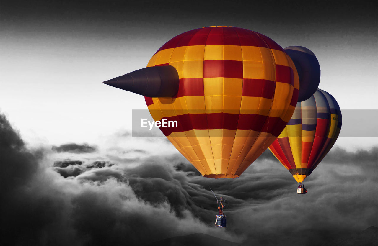 Hot air balloons flying in cloudy sky