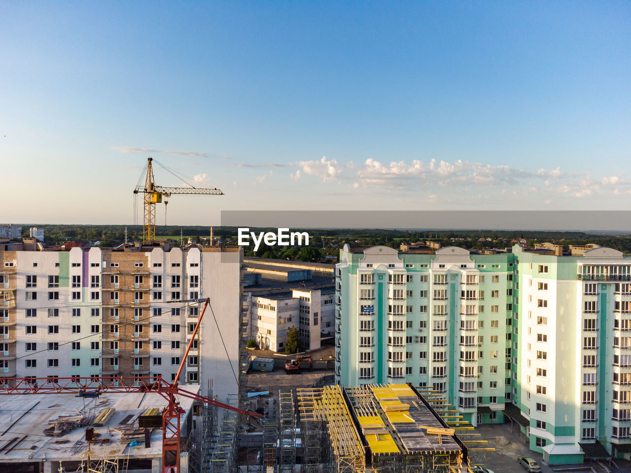 CRANES IN CITY AGAINST SKY