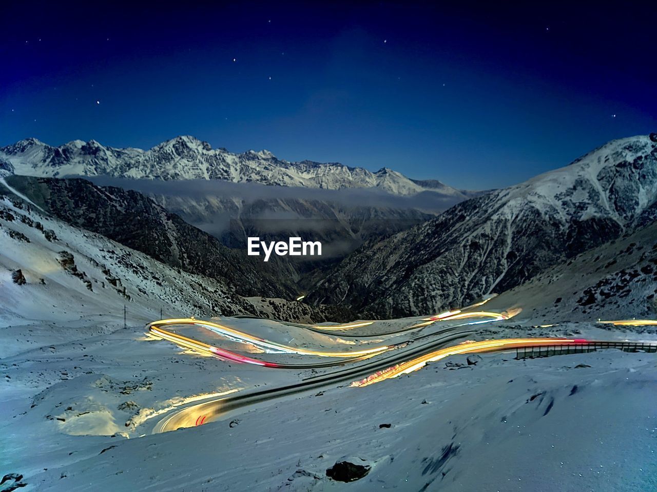 Scenic view of snowcapped mountains against blue sky at night