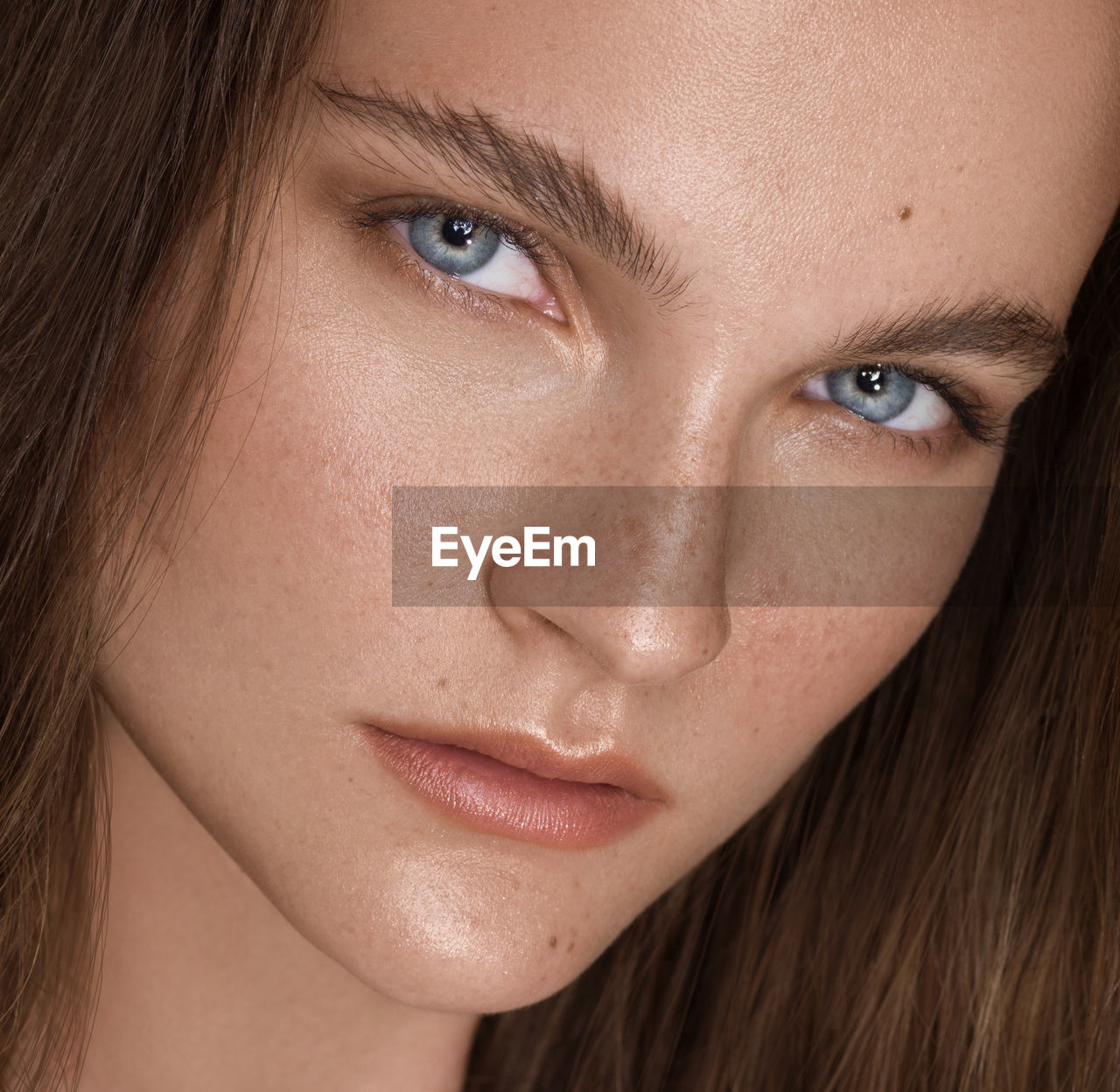 Close-up portrait of young woman with gray eyes and brown hair